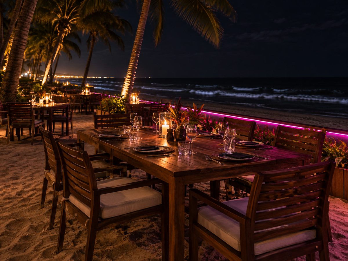 Night terrace on a Negombo beach, magenta neon glow on empty tables, dark sea beyond